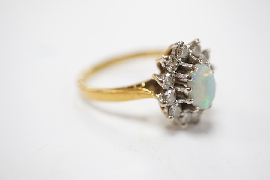 A modern 18ct gold, white opal and diamond set oval cluster ring, size M/N, gross weight 4.6 grams, the opal weighing approximately 0.50ct, total diamond weight approx. 0.48ct. Condition - fair to good